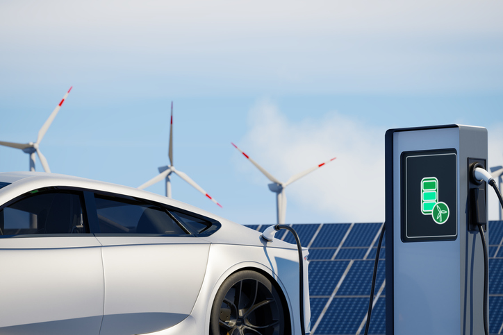 Modern sports electric car charging on background of solar panels. EV station with port plugged in environmentally friendly vehicle